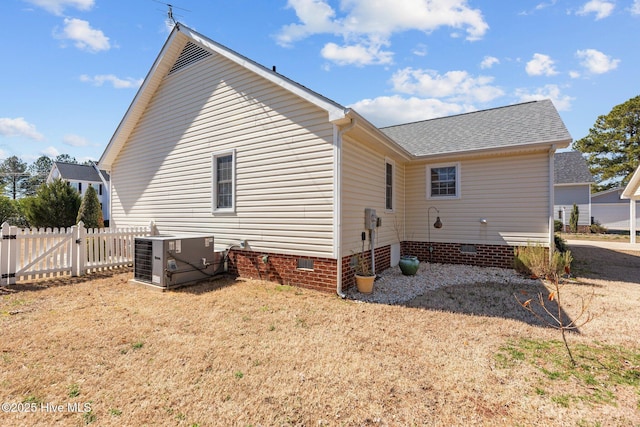 back of property featuring central AC unit, roof with shingles, crawl space, a gate, and fence