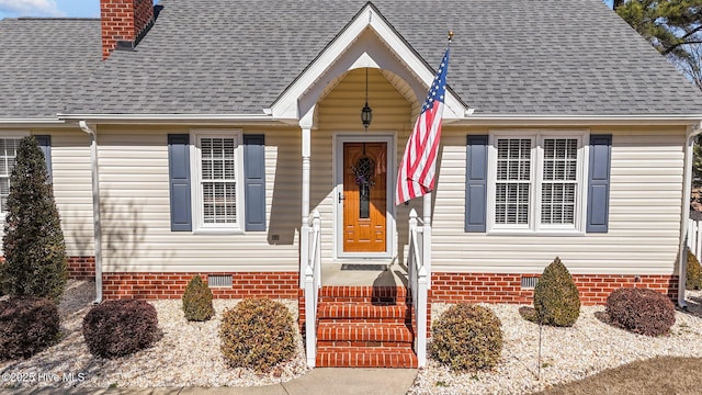 view of front of house with crawl space, a shingled roof, and a chimney