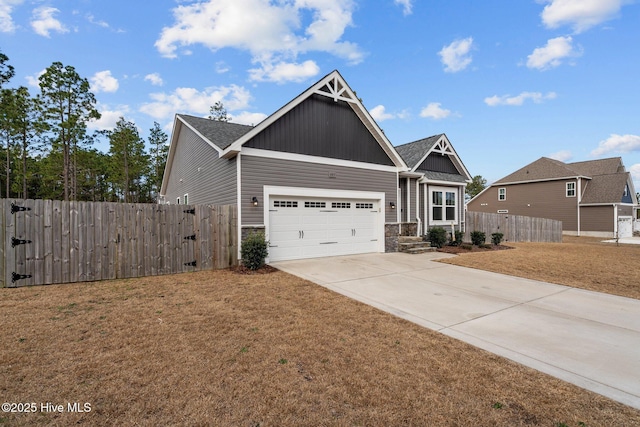 craftsman inspired home featuring concrete driveway, stone siding, an attached garage, fence, and a front yard