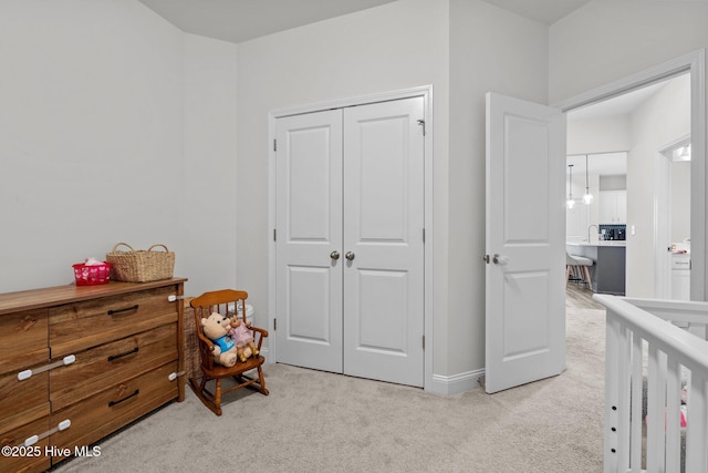 bedroom featuring a closet, light carpet, and baseboards