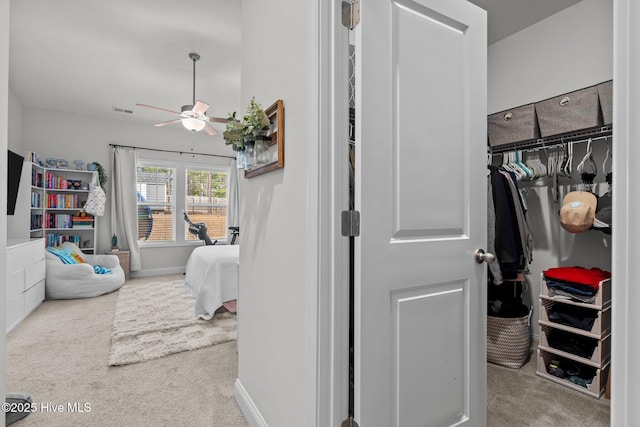 spacious closet featuring a ceiling fan, visible vents, and carpet flooring