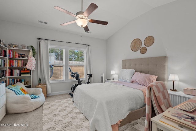 carpeted bedroom with baseboards, visible vents, vaulted ceiling, and a ceiling fan