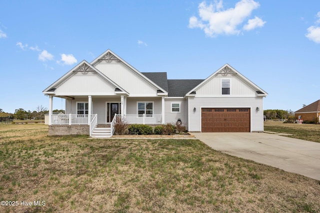 view of front of home featuring a porch, concrete driveway, an attached garage, and a front lawn