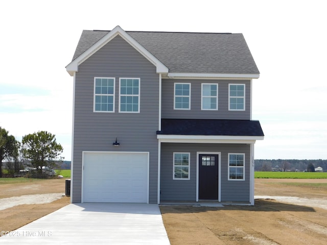 view of front of house with a garage, concrete driveway, and a shingled roof