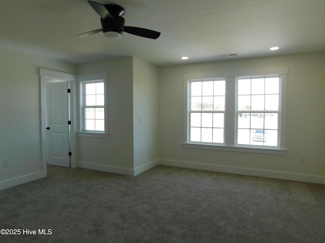 carpeted spare room featuring baseboards, visible vents, and a wealth of natural light