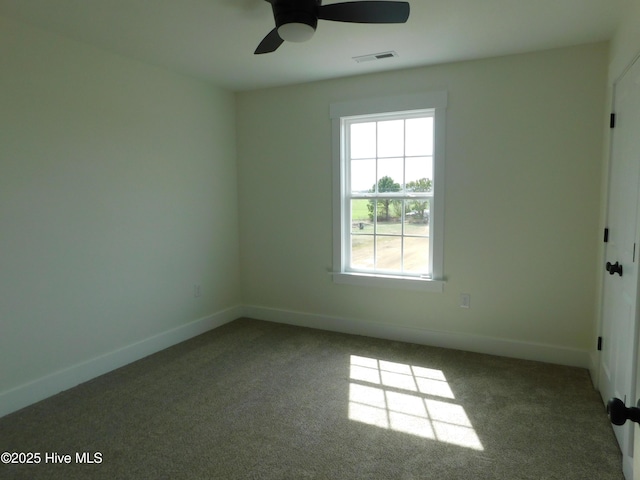 carpeted empty room featuring baseboards, visible vents, and ceiling fan