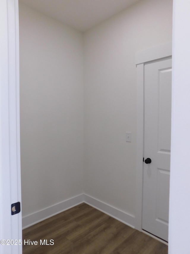 spare room featuring dark wood finished floors and baseboards