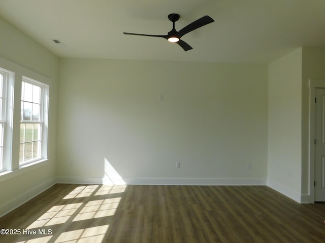 spare room with baseboards, visible vents, ceiling fan, and wood finished floors