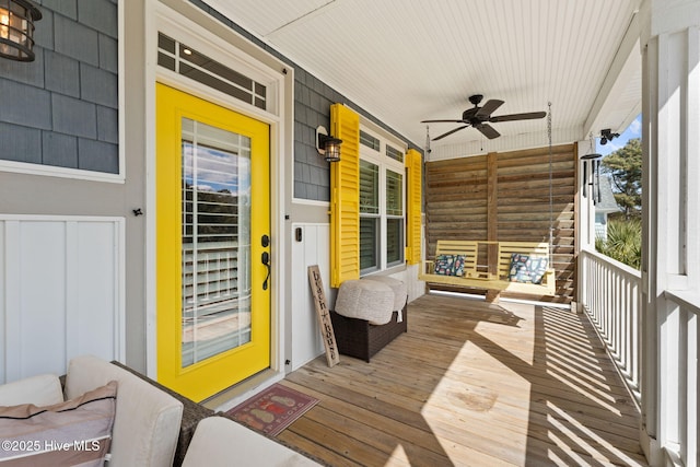 wooden terrace featuring covered porch and ceiling fan