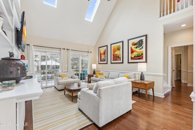 living area with wood finished floors, high vaulted ceiling, and a skylight