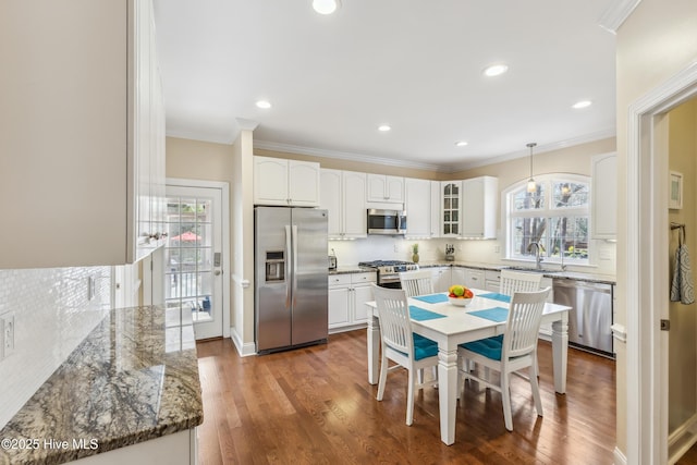 kitchen with backsplash, appliances with stainless steel finishes, and crown molding