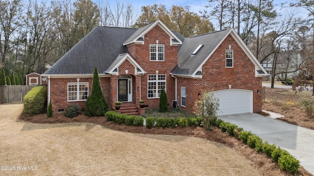 traditional-style house with brick siding, fence, roof with shingles, a garage, and driveway