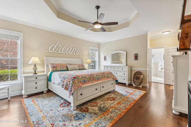 bedroom with a tray ceiling, baseboards, dark wood-type flooring, and ornamental molding