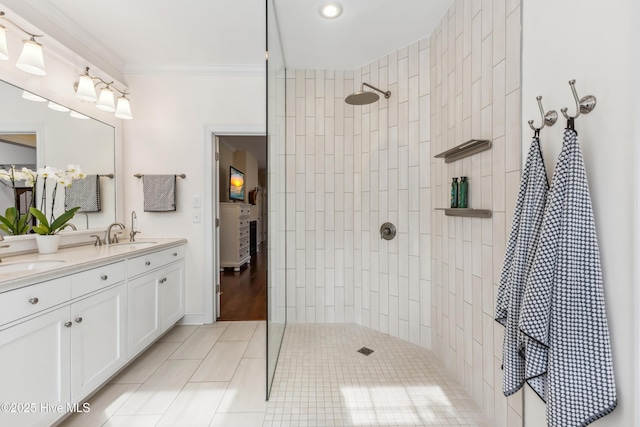 bathroom featuring crown molding, a walk in shower, double vanity, and a sink