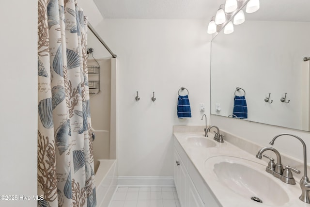 full bathroom featuring a sink, baseboards, double vanity, and tile patterned floors