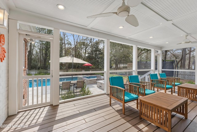 sunroom / solarium featuring a healthy amount of sunlight and a ceiling fan