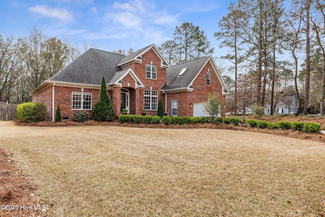 traditional-style house with a front yard, fence, brick siding, and roof with shingles