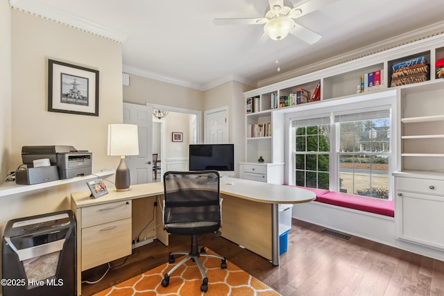 office area with dark wood-style floors, visible vents, a ceiling fan, and ornamental molding