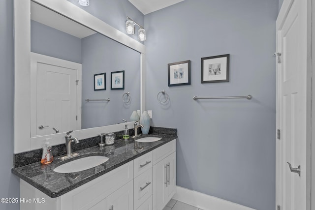 full bath with a sink, baseboards, and double vanity