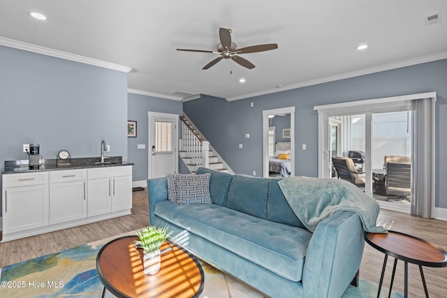 living area with stairs, recessed lighting, visible vents, and light wood-style floors