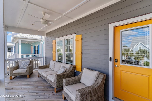 wooden deck featuring an outdoor living space and a ceiling fan