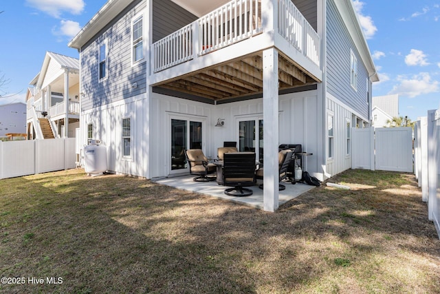 rear view of house featuring a fenced backyard, board and batten siding, and a patio