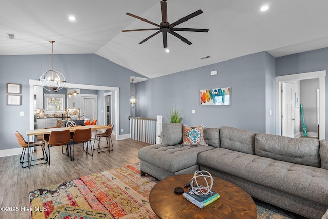 living area with baseboards, visible vents, wood finished floors, vaulted ceiling, and recessed lighting