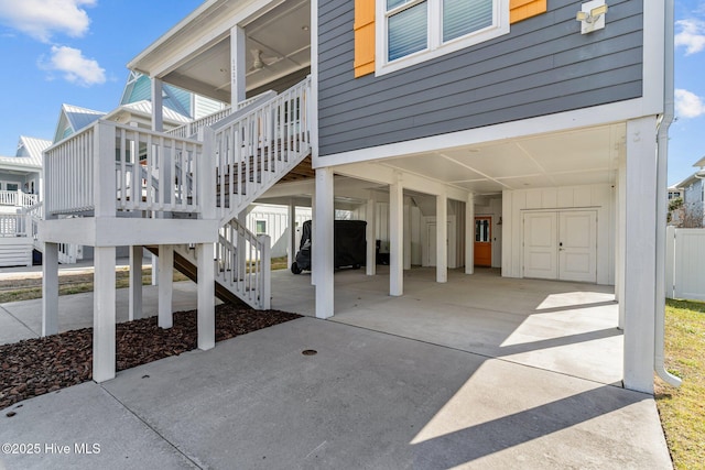 view of patio featuring stairs, a carport, and concrete driveway