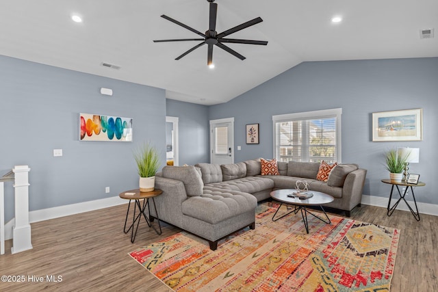 living area with lofted ceiling, baseboards, visible vents, and wood finished floors