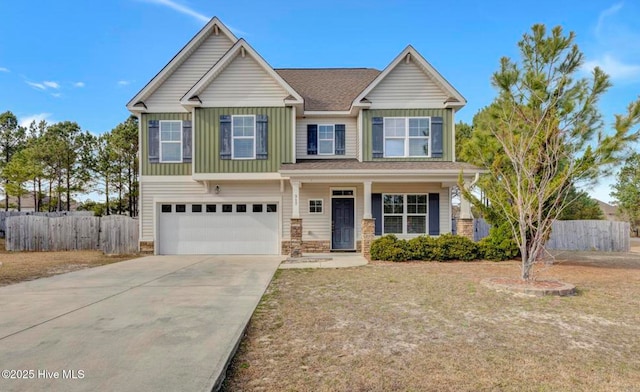 craftsman-style home featuring an attached garage, fence, board and batten siding, and concrete driveway