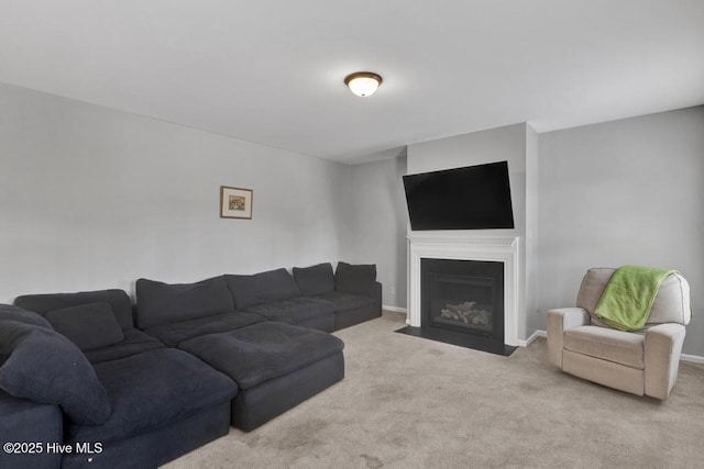 living area with a fireplace with flush hearth, carpet flooring, and baseboards