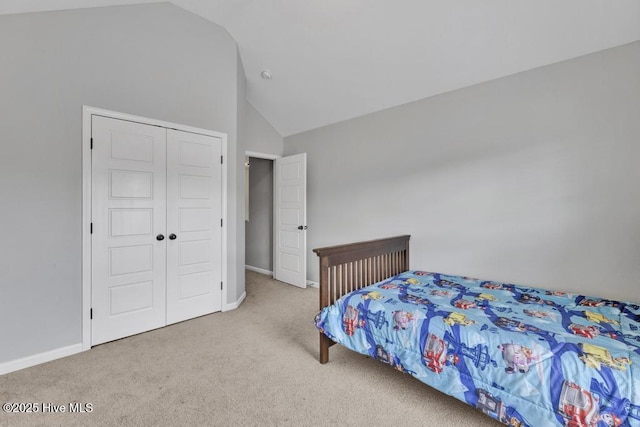 bedroom featuring vaulted ceiling, carpet floors, a closet, and baseboards