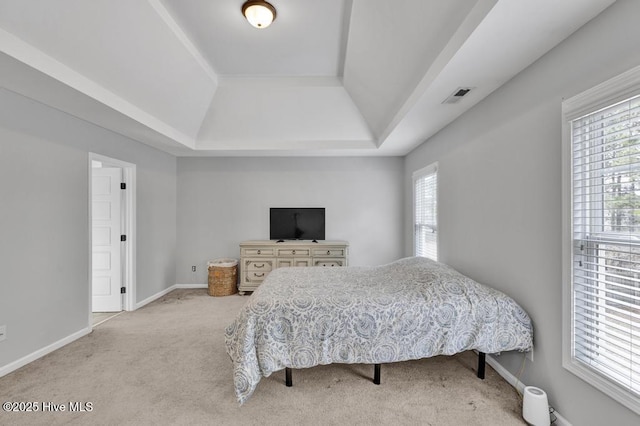 carpeted bedroom with a raised ceiling, visible vents, and baseboards