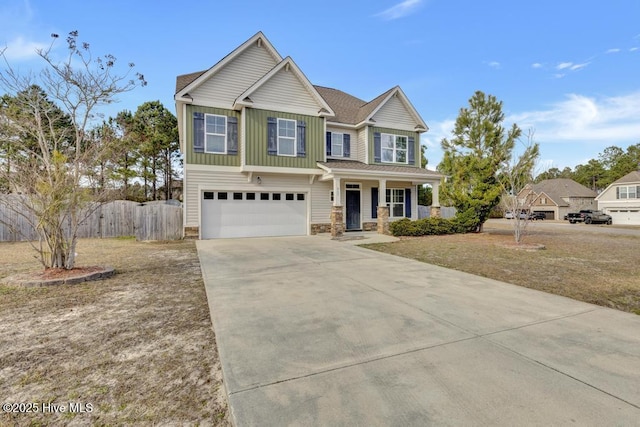 craftsman inspired home featuring a garage, covered porch, fence, concrete driveway, and board and batten siding