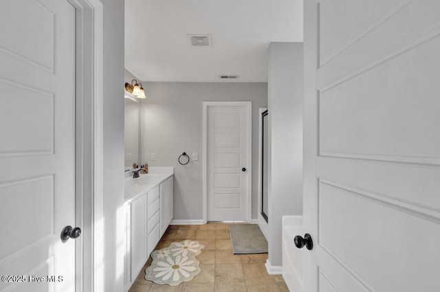 full bathroom with a stall shower, baseboards, visible vents, and vanity