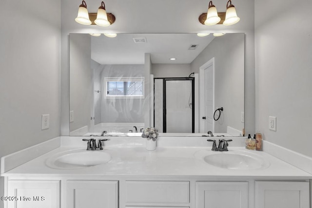 full bathroom featuring double vanity, a stall shower, visible vents, and a sink