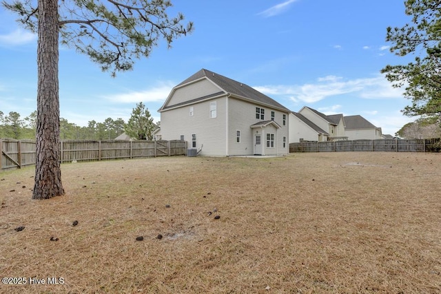 rear view of house with a yard, cooling unit, and a fenced backyard