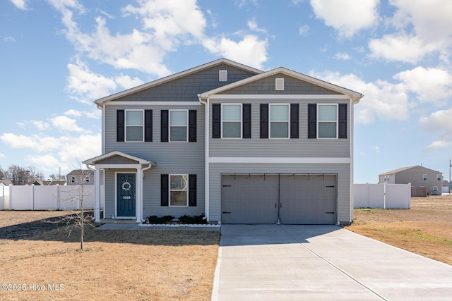 view of front of home with driveway, an attached garage, and fence