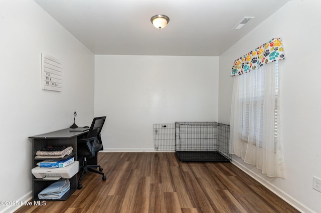 home office with baseboards, visible vents, and wood finished floors