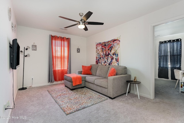 living area featuring carpet flooring, a ceiling fan, and baseboards