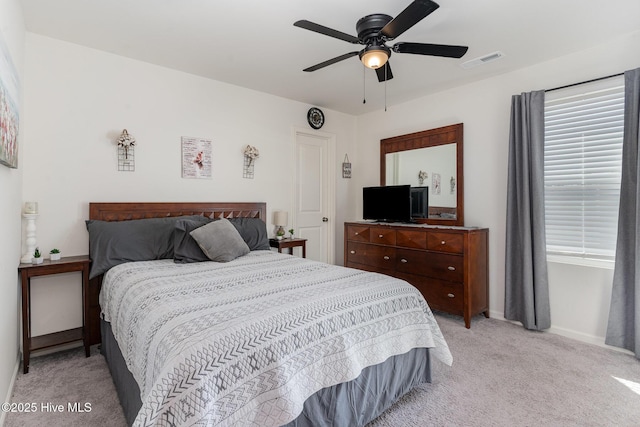 bedroom featuring a ceiling fan, visible vents, light carpet, and baseboards