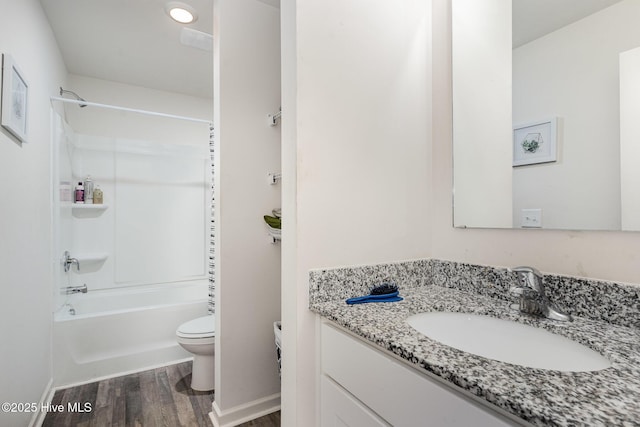 full bath featuring shower / tub combination, toilet, wood finished floors, vanity, and baseboards