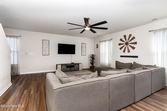 living area with visible vents, baseboards, and wood finished floors