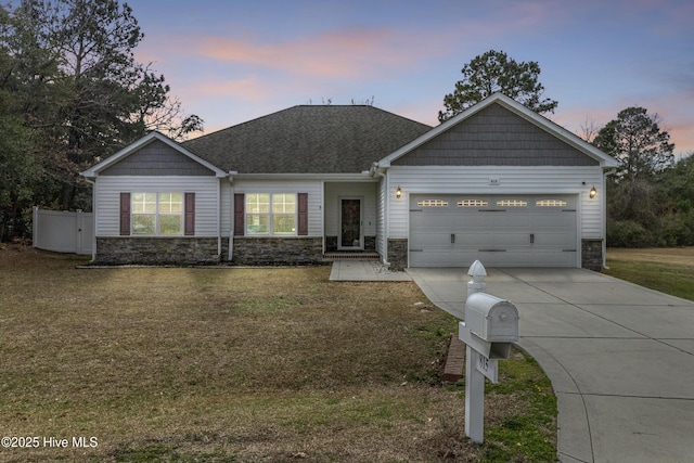 craftsman house featuring concrete driveway, roof with shingles, a yard, and an attached garage