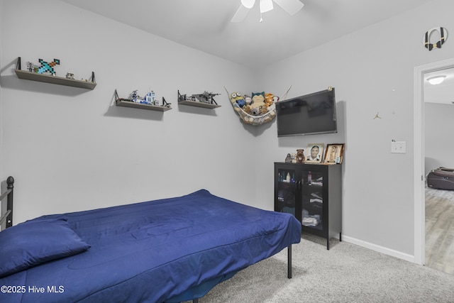 carpeted bedroom with a ceiling fan and baseboards