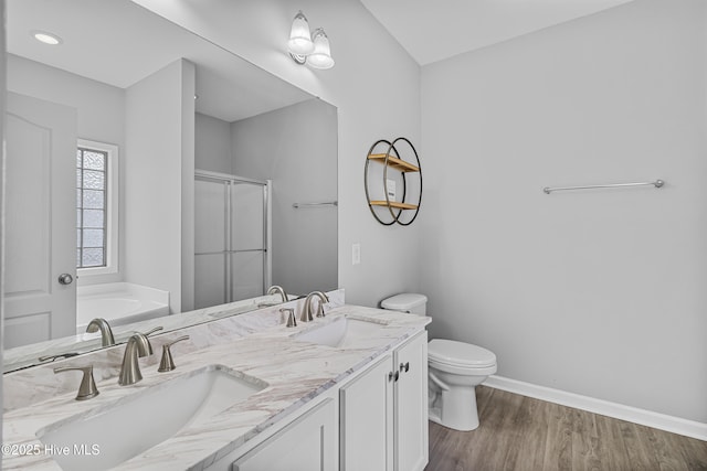 bathroom featuring a stall shower, a sink, toilet, and baseboards