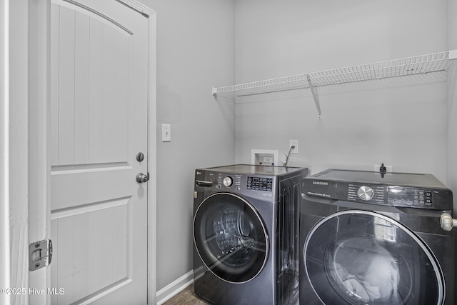 laundry area featuring laundry area, wood finished floors, washing machine and dryer, and baseboards