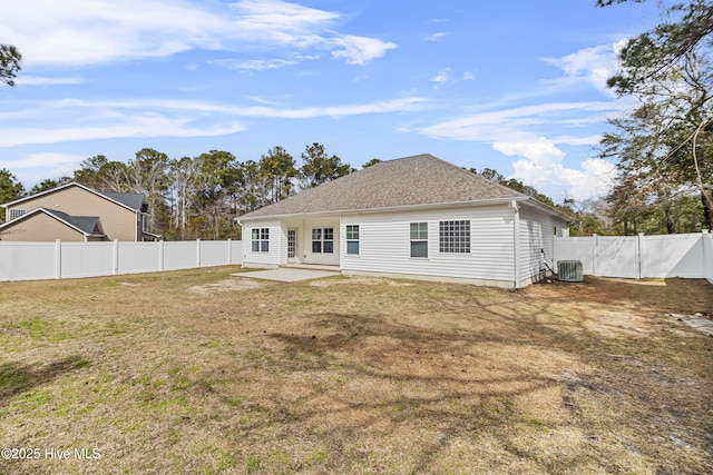 rear view of house featuring a yard, a shingled roof, a patio area, cooling unit, and a fenced backyard