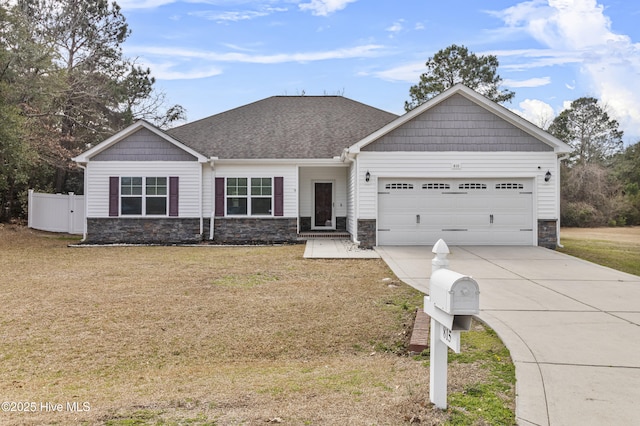 craftsman-style house featuring an attached garage, stone siding, concrete driveway, and a front yard