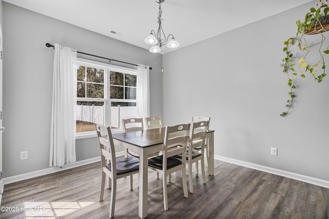 dining space featuring a chandelier, wood finished floors, visible vents, and baseboards